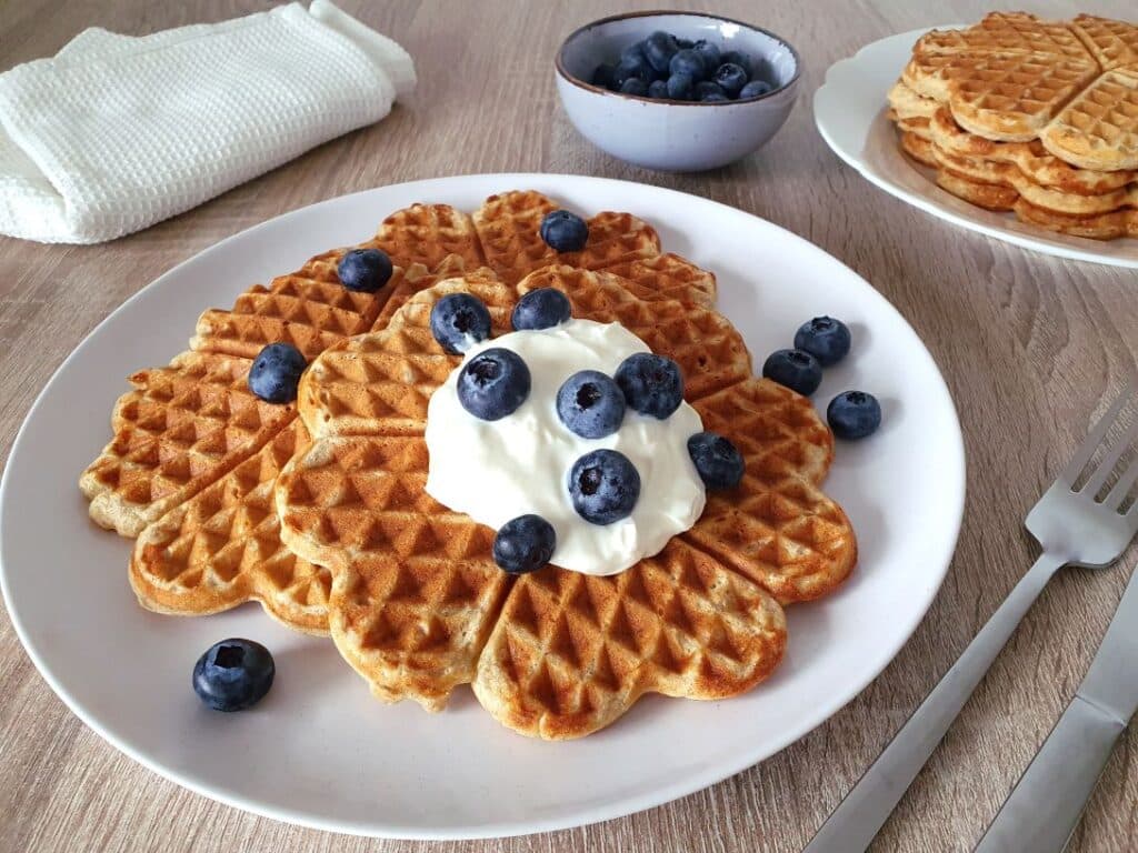 Gesunde Protein Waffeln auf einem weißen Teller mit Blaubeeren und Quark