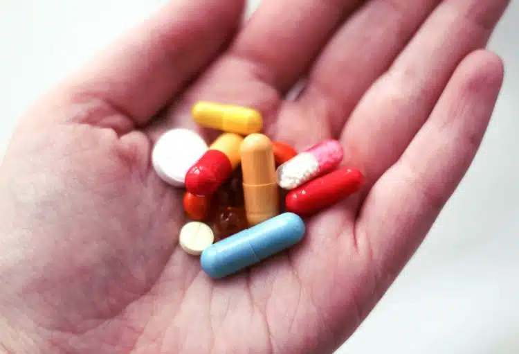 Hand mit PCO Nahrungsergänzungsmitteln